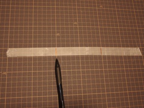 メンディングテープを剥がして長さを測ります。1.5Lコーラのペットボトルの円周は約30cmであることが分かりました。それを三等分して印を書きます。